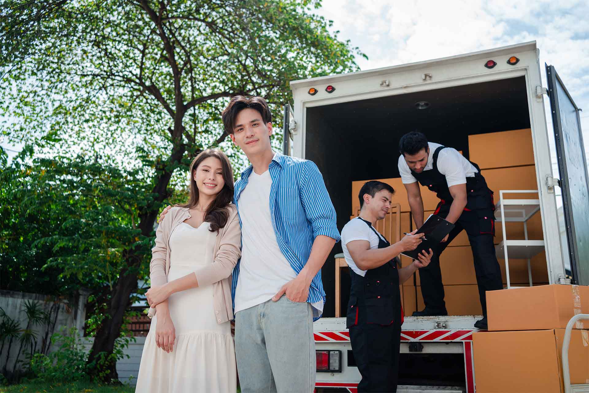 couple standing next to men loading a moving truck