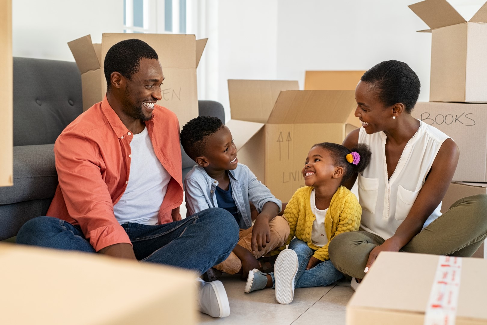 family sitting together with moving boxes